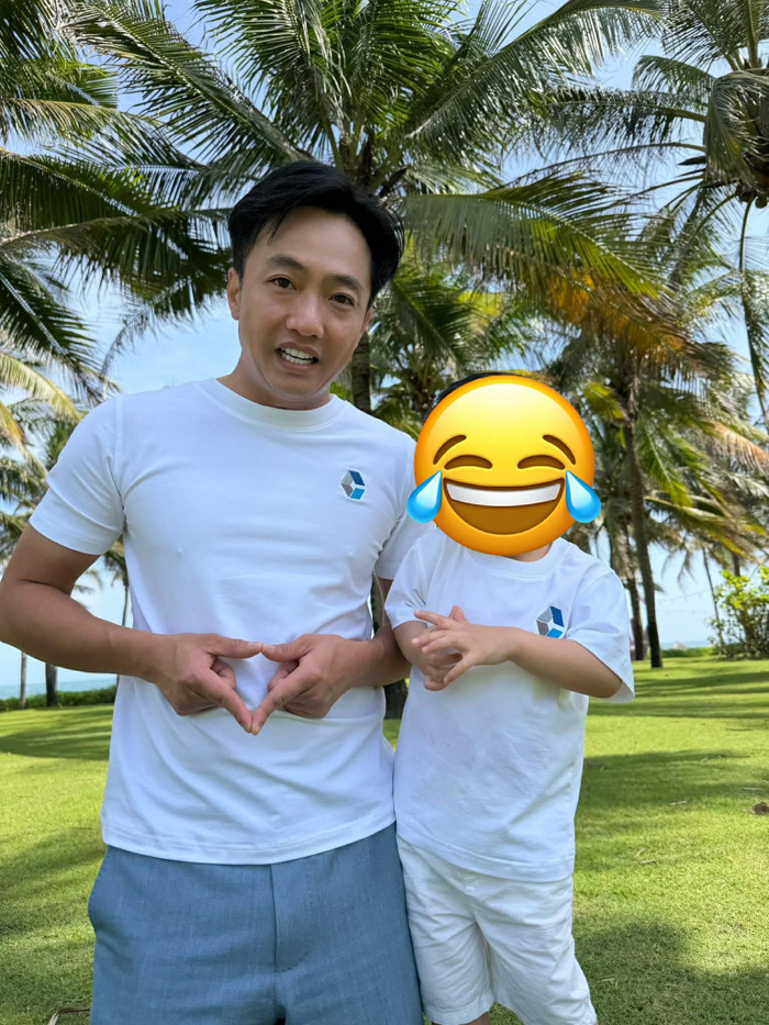 Một điểm đáng chú ý khác trong phong cách của Cường Đô La là cách anh xử lý layering và phối màu trong các outfit hàng ngày. Trong bức ảnh chụp cùng con trai, chiếc áo thun trắng basic với logo thêu tinh xảo được kết hợp cùng quần shorts linen xám nhạt, tạo nên sự thoải mái và năng động, phù hợp với khí hậu nhiệt đới. Chất liệu cotton cao cấp của áo giúp form dáng luôn gọn gàng dù vận động nhiều, trong khi quần linen mang lại cảm giác nhẹ nhàng, chống nhăn tốt. Đây là lựa chọn thực tế cho doanh nhân thường xuyên di chuyển. Ảnh: FBNV