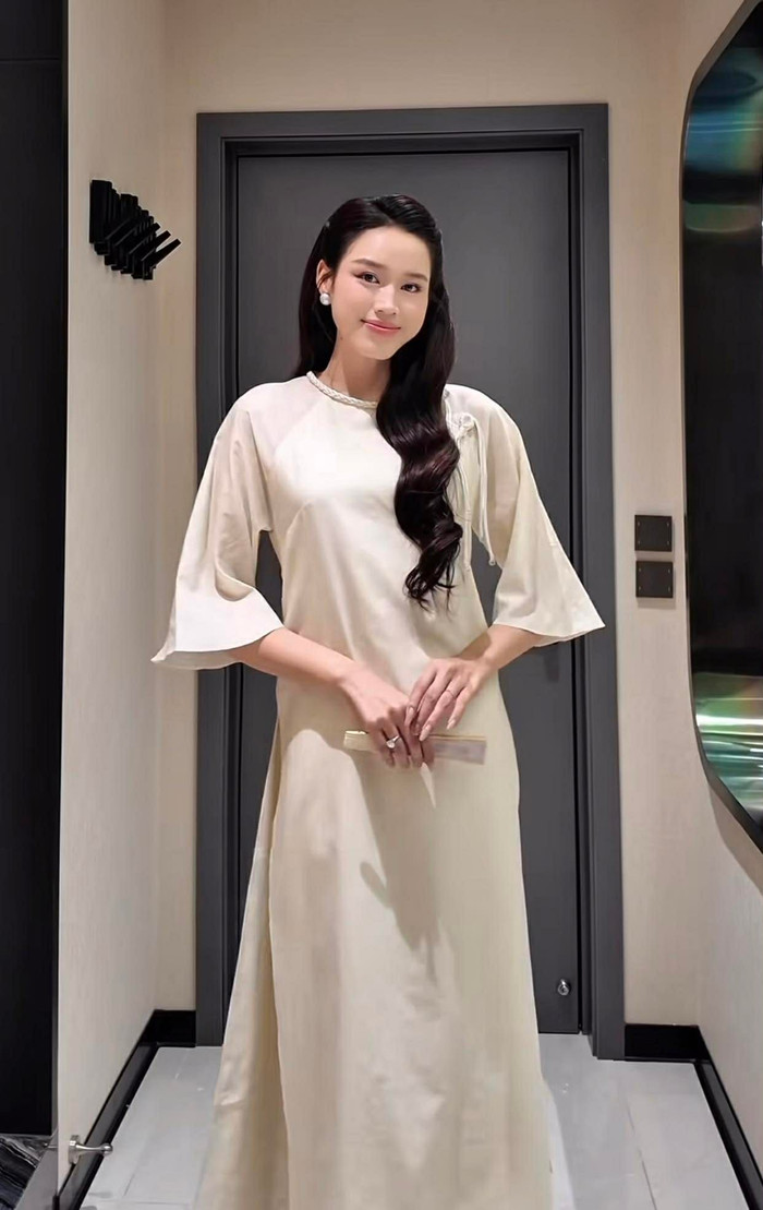 Tiếp nối tinh thần Á Đông, Đỗ Thị Hà ưu ái thiết kế lụa kết hợp tơ nhũ ánh nhẹ đầy tinh tế. Điểm nhấn của bộ trang phục nằm ở phần thân áo dệt hoa văn chìm, tay raglan suông rộng phóng khoáng và cổ trụ nhỏ với hàng khuy bọc thủ công tinh xảo. Khi được phối cùng quần lụa hồng pastel, bộ cánh không chỉ tôn lên nét thanh lịch đặc trưng của người phụ nữ Việt mà còn mang lại cảm giác nhẹ nhàng, bay bổng. Ảnh: FBNV&nbsp;