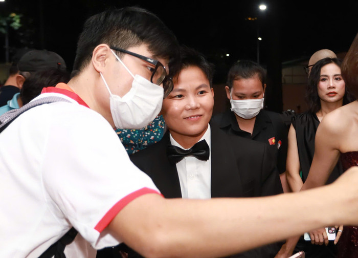 Tiền vệ Bích Thuỳ chụp hình cùng fan ngay sau khi xuất hiện ở cổng sự kiện.&nbsp;