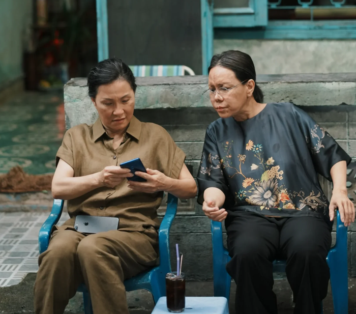 Việt Hương và Hồng Đào trong Cục vàng của ngoại, khoảnh khắc hai nhân vật ngồi cạnh nhau trong không gian hẻm nhỏ