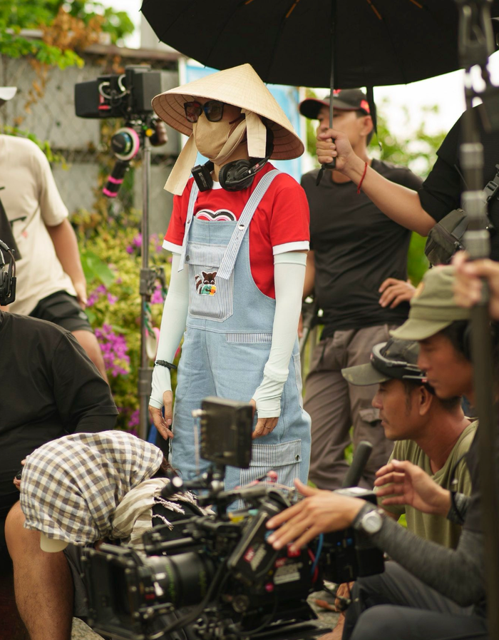 Mỹ Tâm đội nón lá, đeo khẩu trang kín bưng khi ở phim trường cùng Mai Tài Phến và ê-kíp. Ảnh: FBNV