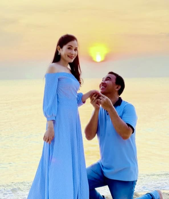 Điểm đặc biệt trong gu thời trang vợ chồng Quyền Linh chính là khả năng chuyển đổi linh hoạt giữa trang phục sự kiện và đời thường. Khi đi biển hay chụp ảnh gia đình, cặp đôi thường chọn tông màu xanh dương tươi trẻ. Trong bức ảnh, Quyền Linh diện áo polo xanh navy phối quần dài cùng tông, mang lại cảm giác thoải mái, năng động. Bà xã anh xuất hiện trong chiếc váy maxi xanh nhạt thoáng mát, tạo sự đồng bộ màu sắc nhưng vẫn giữ nét dịu dàng riêng.&nbsp;