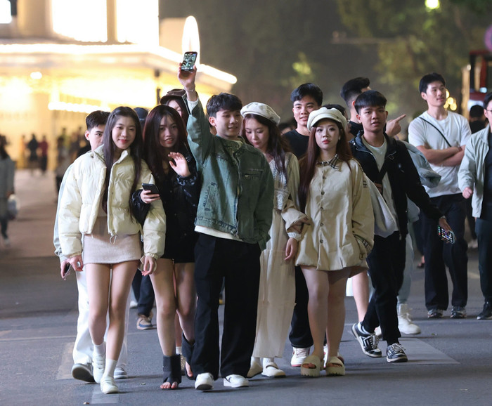 Giới trẻ xúng xính váy áo, đổ về khu vực Hồ Hoàn Kiếm chờ đợi phút giây Giao thừa Ảnh 6