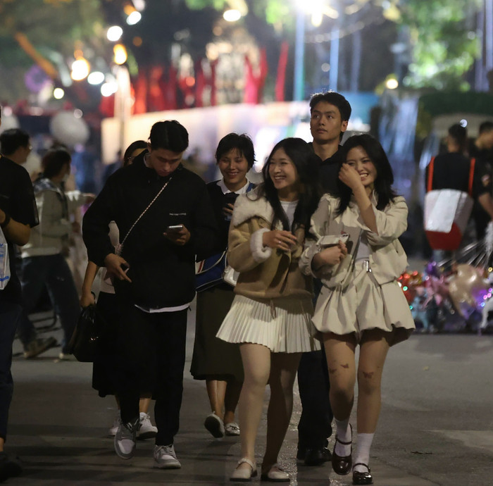 Giới trẻ xúng xính váy áo, đổ về khu vực Hồ Hoàn Kiếm chờ đợi phút giây Giao thừa Ảnh 4