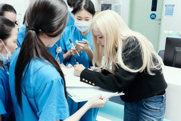 Rosé cho chữ ký khi đến bệnh viện phát quà cho các em nhỏ. Ảnh: IGNV