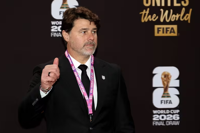 Mauricio Pochettino chọn suit đen toàn bộ, áo sơ mi trắng và cà vạt đen đồng điệu, kèm dây đeo badge sự kiện màu hồng nổi bật. Bộ suit có form dáng slim-fit hiện đại, vai áo cấu trúc rõ ràng, phù hợp với vóc dáng cao ráo của ông. Lớp lót bên trong và nút áo chất lượng cao cho thấy đây là sản phẩm từ các nhà mốt lớn. Có thể thấy Pochettino thường ưu tiên tông màu tối để tạo cảm giác mạnh mẽ, tự tin trên thảm đỏ World Cup 2026. Ảnh: FIFA