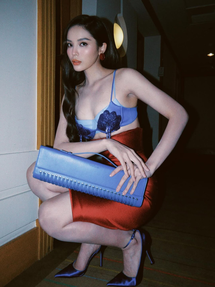 Về trang điểm, Kỳ Duyên thường chọn phong cách sắc nét, tập trung vào đôi mắt khói và môi son đậm, phù hợp với các bộ trang phục gợi cảm. Lớp foundation mịn màng kết hợp highlighter nhẹ nhàng giúp làn da của nàng hậu luôn rạng rỡ dưới ánh đèn, nhấn mạnh vào đường nét khuôn mặt. Ảnh: IGNV