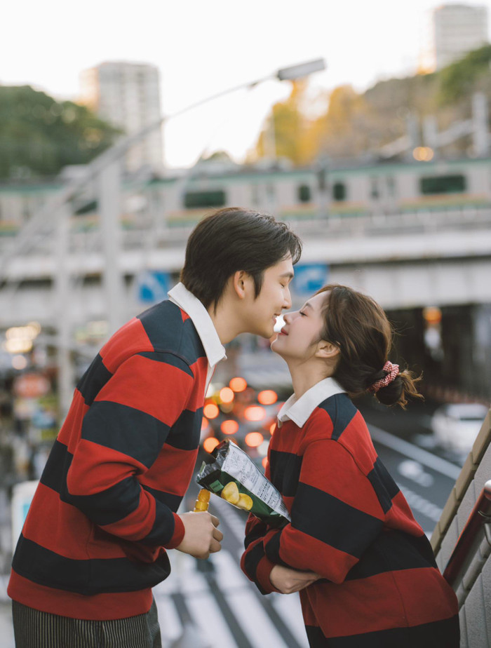  Vợ chồng Đình Tú xuất hiện với trang phục áo len kẻ ngang đỏ - đen (Ảnh: FBNV)