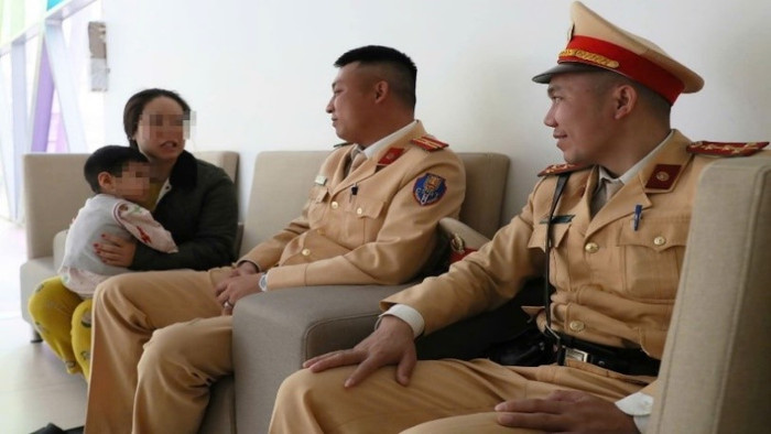 Đại úy Nguyễn Tiến Cảnh và Thiếu tá Nguyễn Văn Dũng thăm cháu bé tại Bệnh viện. Ảnh: Công an TP Hà Nội