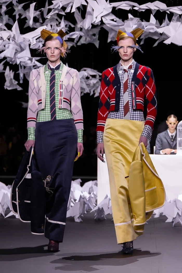 Cặp đôi người mẫu diện bộ trang phục lòe loẹt, tương phản về màu sắc ẩn dụ cho những chú chim ngoài tự nhiên. (Ảnh: Thom Browne Fall 2025)