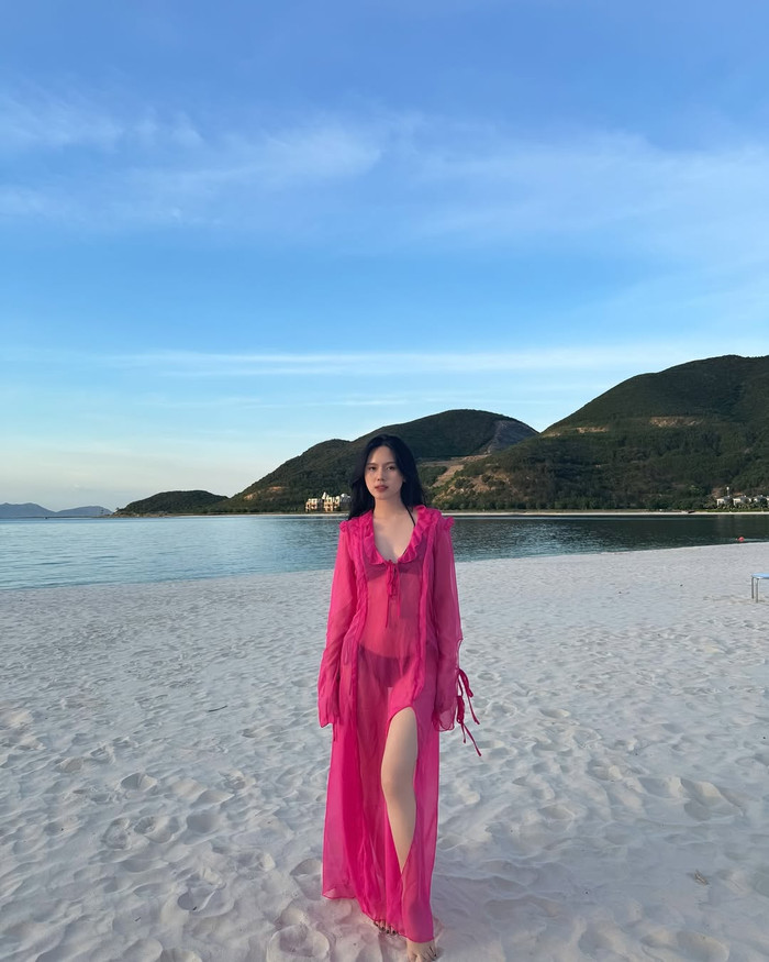 Trong hình ảnh này, vợ Thành Chung khoác lên người chiếc bikini hai mảnh 'tí hon' màu đen tối giản, không có quá nhiều họa tiết. Tố Uyên khéo léo kết hợp thêm chiếc váy dáng dài bên ngoài, mang tông màu hồng nổi bật. Thiết kế này được làm từ chất liệu xuyên thấu và để lộ chiếc bikini bên trong. Màn 'lên đồ' giúp vợ Thành Chung khoe khéo vóc dáng nóng bỏng nhưng không hở hang quá nhiều da thịt. (Ảnh: FBNV)