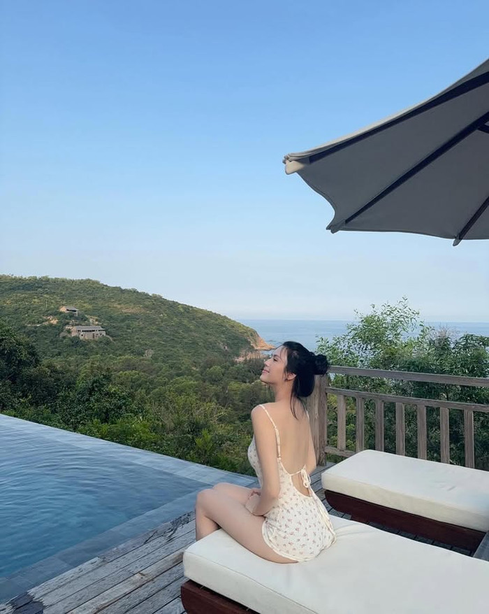 Bộ sưu tập thời trang đi biển của vợ Thành Chung còn có sự góp mặt của chiếc jumpsuit liền thân màu trắng. Thiết kế này được khoét mảng lớn phía sau giúp Tố Uyên khoe trọn tấm lưng trần. Đặc biệt, điểm nhấn của chiếc jumpsuit còn nằm ở họa tiết hoa nhí tăng phần ngọt ngào và nữ tính. (Ảnh: FBNV)