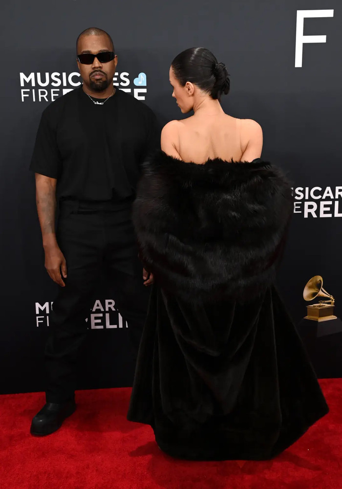 Kanye West sánh đôi cùng vợ kiến trúc sư Bianca Censori trên thảm đỏ. Bianca Censori khoác lên người chiếc áo choàng lông dáng dài, mang tông màu đen đồng điệu với nam rapper đình đám. 