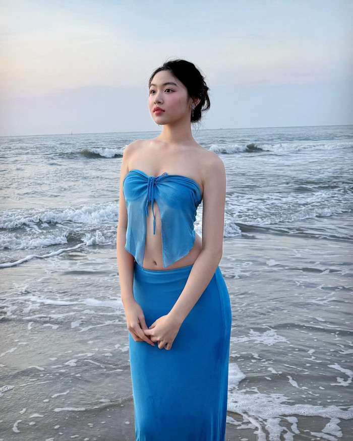 Chiếc váy được thiết kế theo phong cách cắt xẻ táo bạo, với phần áo ngắn buộc nơ trước ngực, để lộ phần xương quai xanh thanh mảnh và vòng eo con kiến, những chi tiết khiến vóc dáng của cô trông càng quyến rũ.