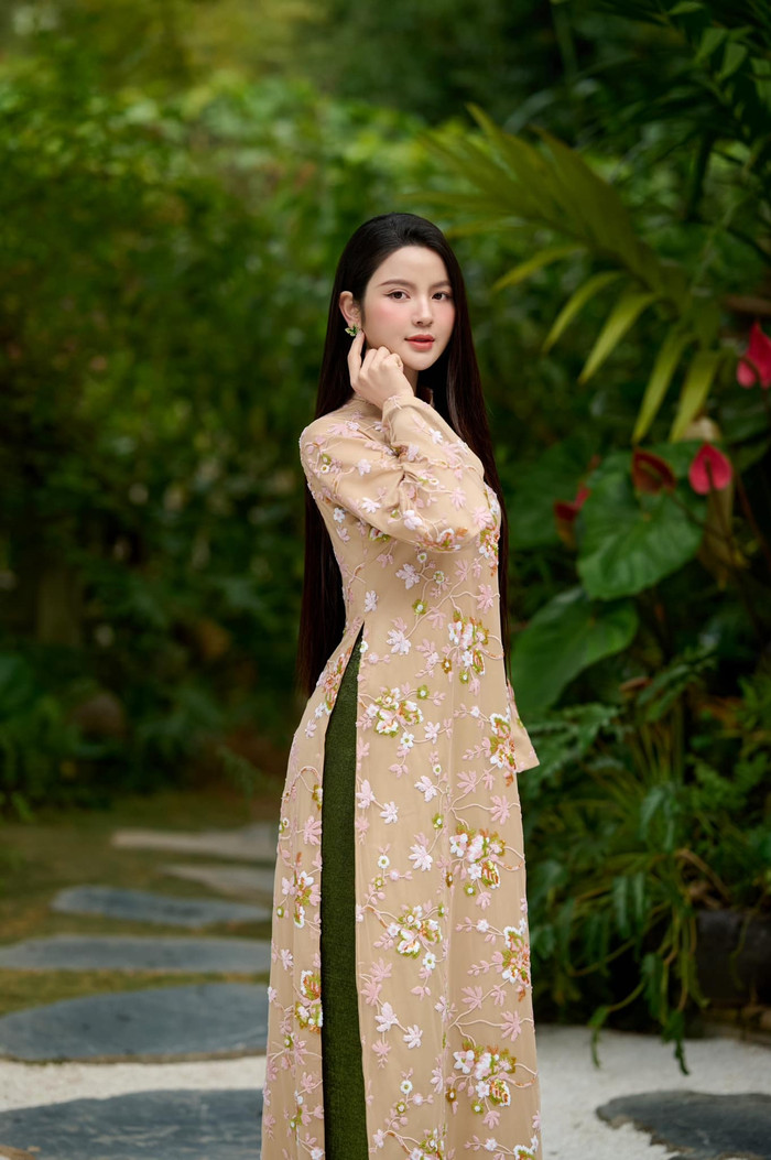 Vợ Quang Hải khoác lên người chiếc áo dài truyền thống, phối giữa hai gam màu beige và xanh bơ. Đặc biệt, thiết kế này còn được tạo điểm nhấn bằng loạt họa tiết hoa, được thêu nổi trải dài từ cổ xuống đến phần tà áo dài. Thiết kế này được đánh giá 'kén' người mặc, dễ khiến phái đẹp trở nên 'dừ' đi trông thấy. Tuy nhiên, Chu Thanh Huyền lại dễ dàng chinh phục trang phục này. (Ảnh: FBNV)