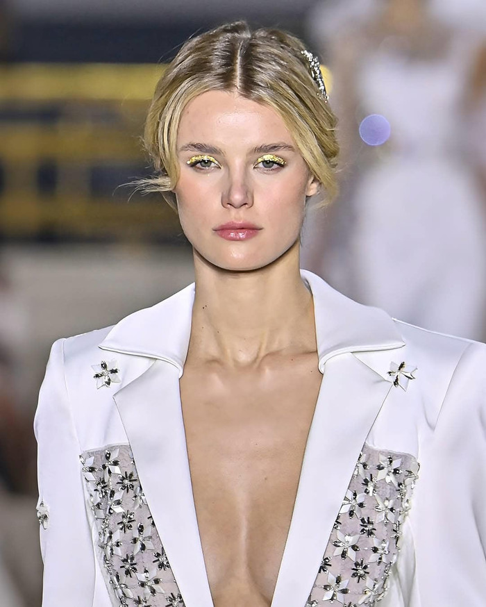 Đương kim Hoa hậu Thế giới trình diễn thời trang với gương mặt nhợt nhạt, chỉ nhấn nhá ở đôi mắt. (Ảnh tổng hợp)