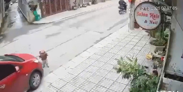 Hình ảnh bé trai đứng trước đầu ô tô trước khi xảy ra tai nạn. Ảnh trích từ camera an ninh