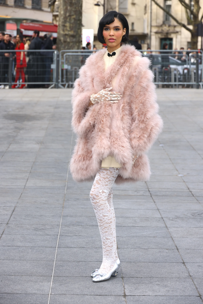 Mới đây, cô tham dự Valentino thu đông 2025 với một chiếc áo lông màu hồng pastel đầy sang trọng và nữ tính. Kết hợp với màu chủ thể hồng là chi tiết ren ở quần tất và găng tay. Nhìn chung, đây là một bộ trang phục mang đậm chất hơi hướng của nhà mốt này và cũng làm tôn lên vẻ đẹp quyến rũ cũng như thanh lịch của cô.