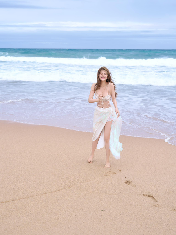 Phần chân váy xuyên thấu ánh ngọc trai mang đến vẻ ngoài bay bổng, nhẹ nhàng, giúp tổng thể trông vừa thanh thoát vừa hiện đại. Đây là một trong những cách kết hợp trang phục biển được nhiều fashionista ưa chuộng – tôn vinh nét gợi cảm nhưng vẫn giữ được sự sang trọng.