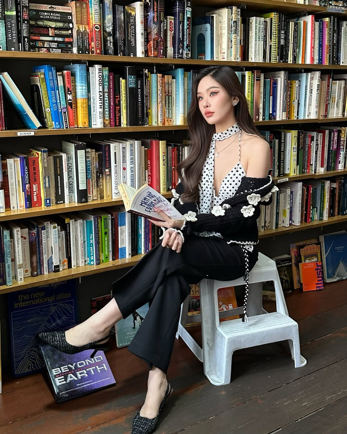 Malin Chara-anan - đương kim Miss Grand Thailand diện chiếc áo xẻ sâu, khoe vẻ gợi cảm giữa không gian tiệm bán sách. (Ảnh: Instagram nhân vật)
