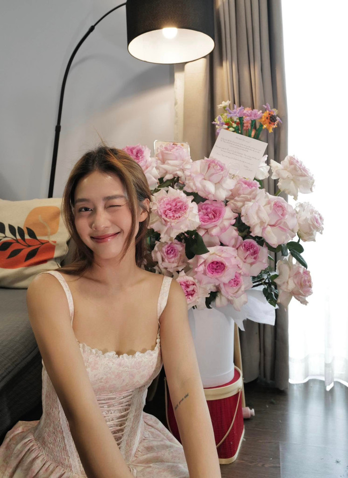 Khả Ngân cười mỉm khi đón nhận lẵng hoa lớn. Ảnh: FBNV