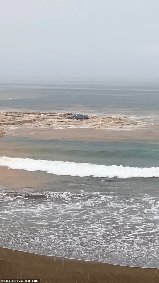 Một chiếc ô tô đã bị kéo hàng chục mét xuống biển khi hòn đảo phải vật lộn với lượng mưa lớn.