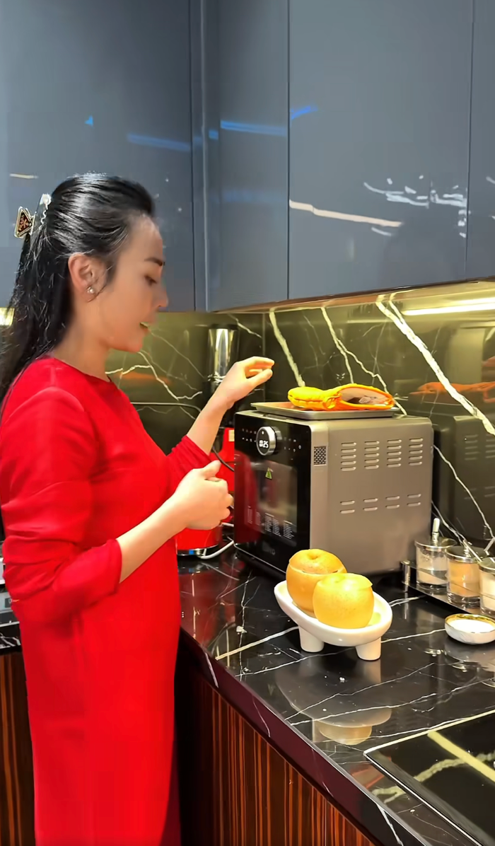 Phương Oanh lấy lê hấp từ trong lò ra để mang ra bàn ăn. Ảnh: FBNV