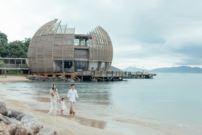 Salim và Hải Long dắt con gái đi trên bãi biển. Ảnh: FBNV