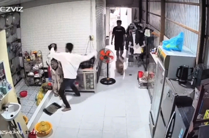 Camera ghi lại cảnh người phụ nữ bị chồng đánh khi đang đứng nấu ăn. Ảnh cắt từ clip