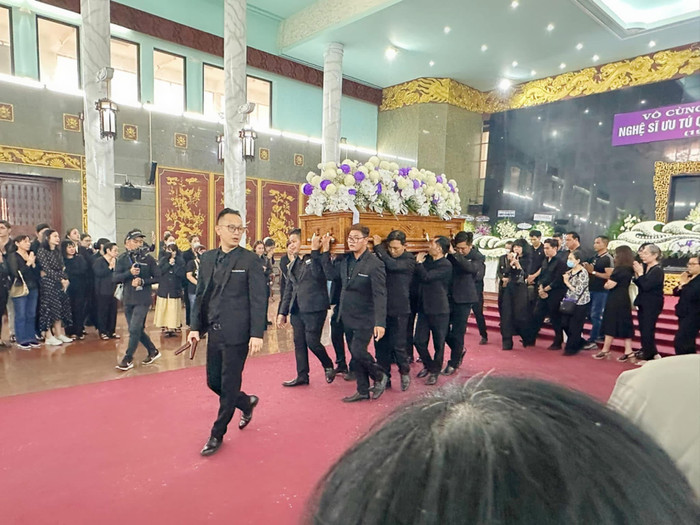 Người thân, bạn bè Quý Bình bịn rịn trong giây phút đưa tiễn linh cữu ra xe tang. Ảnh: Facebook Song Minh