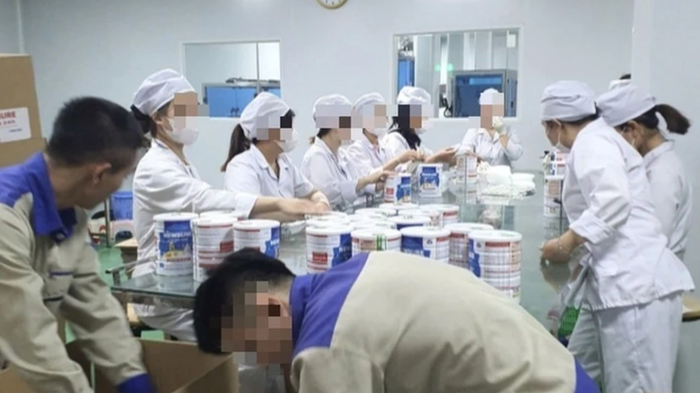 Công nhân đang đóng gói thành phẩm tại cơ sở sản xuất sữa bột giả quy mô lớn vừa bị Công an Hà Nội triệt phá. Ảnh: Báo Công an nhân dân