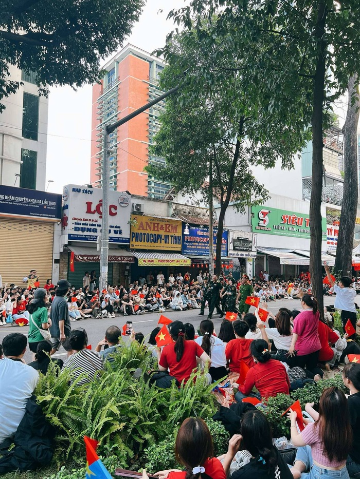 Người dân ngồi kín các trục đường nơi có đoàn diễu binh, diễu hành đi qua sáng 27/4. (Ảnh: Yến Võ)