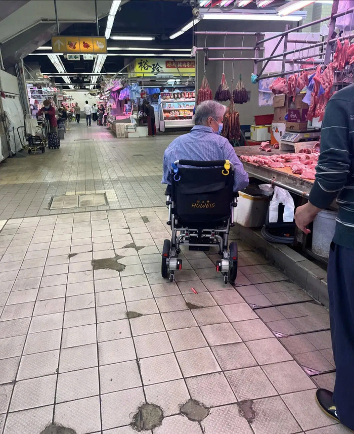 Hồng Kim Bảo ngồi xe lăn đi chợ mua thịt. Ảnh: Weibo