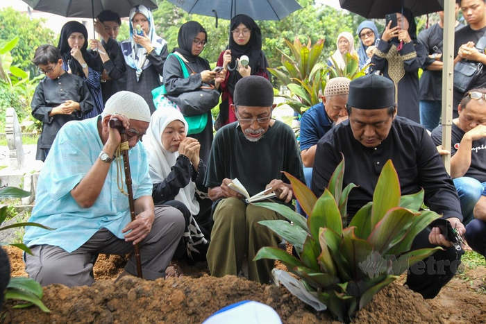 Thân quyến của Nico trong lúc đọc kinh tiễn biệt nam ca sĩ tại nghĩa trang. (Ảnh: Aziah Azmee).