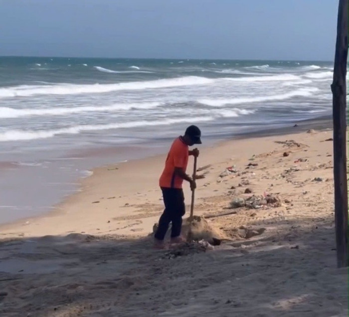Ông M. tự ý chôn lấp rác thải rắn xuống bãi biển gây bức xúc. Ảnh cắt từ clip