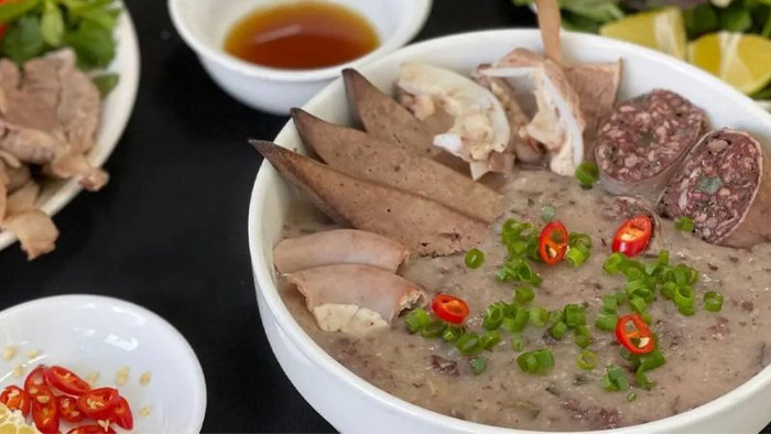 Tô cháo lòng chuẩn vị không thể thiếu những lát nội tạng cắt mỏng, thêm vài miếng quẩy giòn, hành lá, ớt, nước mắm và rau thơm. (Ảnh minh họa)