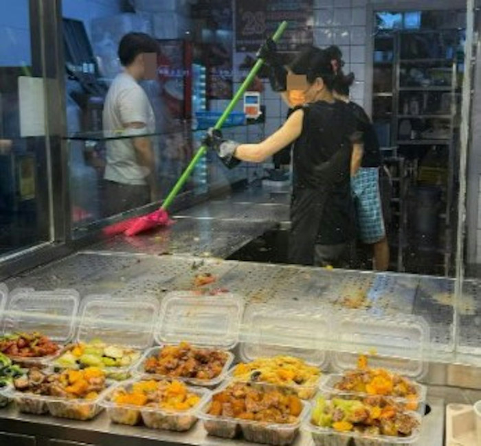 Xôn xao hình ảnh 2 nhân viên nhà hàng dùng chổi để quét khay đựng thức ăn Ảnh 2