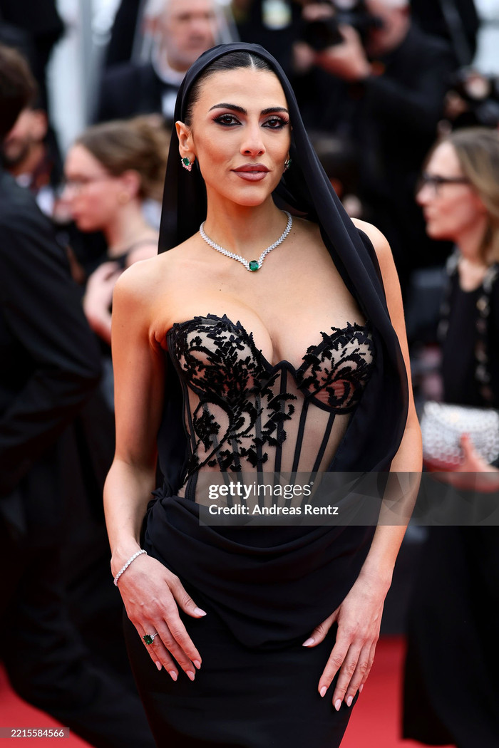 Người mẫu Giulia Salemi khoe sắc vóc phồn thực trên thảm đỏ Liên hoan phim Cannes 2025 ngày thứ 5. Thiết kế thời trang được cô lựa chọn có sự kết hợp của chiếc corset trong suốt giúp định hình vóc dáng. Giulia Salemi còn phối cùng bộ sưu tập trang sức đính đá ngọc bích thu hút và mát mắt.