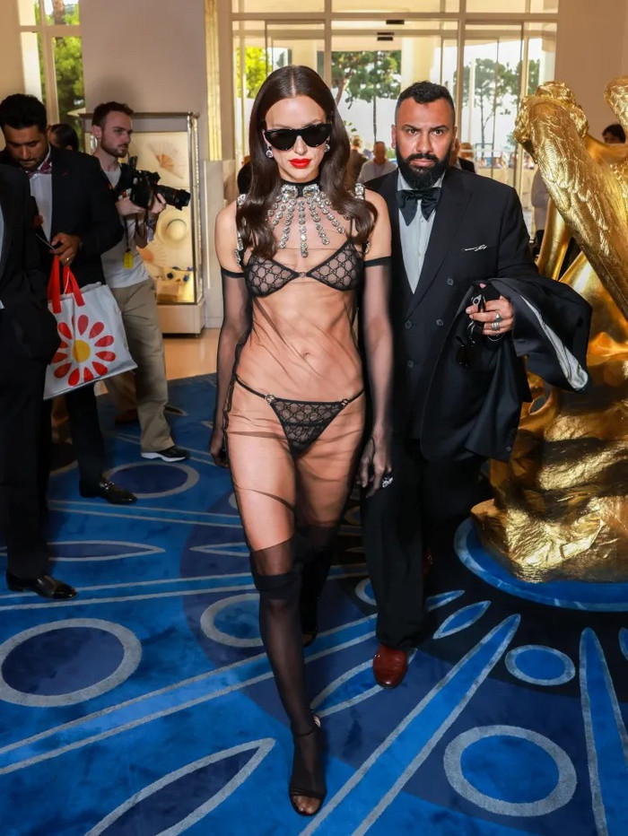 Irina Shayk (2023): Siêu mẫu người Nga đến Cannes trong bộ nội y Gucci thuộc BST Thu/Đông 2023 – gồm áo bra và quần lót đen, kết hợp với đầm lưới xuyên thấu, găng tay lưới và tất dài, phô diễn gần như toàn bộ vóc dáng dưới lớp vải mỏng như sương.