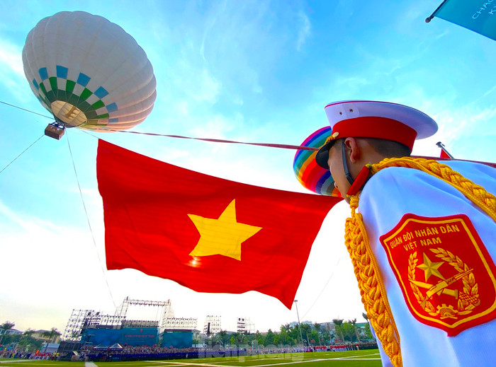 Lá đại kỳ Tổ quốc rộng 2.025m² từ từ được kéo lên cao giữa nền trời xanh biếc trong tiếng nhạc, tung bay mạnh mẽ trong gió. Hình ảnh ấy khiến cả quảng trường như lặng đi trong niềm xúc động. Ảnh: Tiền Phong 