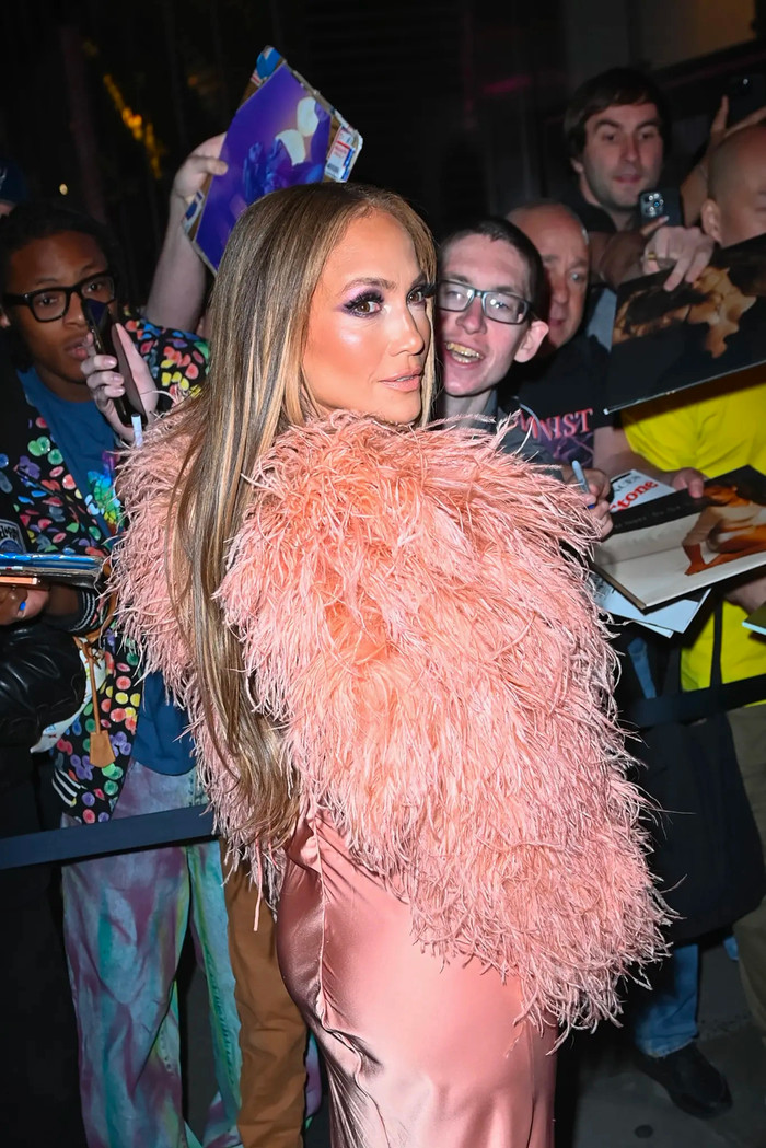Jennifer Lopez khoác lên người chiếc váy hai dây, được làm từ chất liệu lụa bóng bẩy tạo nên cảm giác mềm mại, phóng khoáng. Để tăng thêm phần quý phái, nữ ca sĩ kết hợp cùng chiếc áo lông tua rua. Tổng thể tạo hình của Jennifer Lopez mang tông màu hồng cam nhã nhặn. (Ảnh: Page Six)