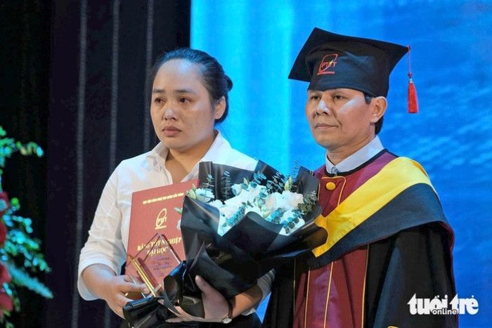 Chị Phương mắt đỏ hoe khi lên nhận bằng tốt nghiệp thay cho em gái. Ảnh: Tuổi Trẻ Online