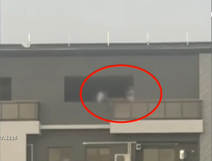 Hai thanh niên ngồi vắt vẻo trên ban công tòa nhà cao tầng trò chuyện, người đi đường thót tim Ảnh 1