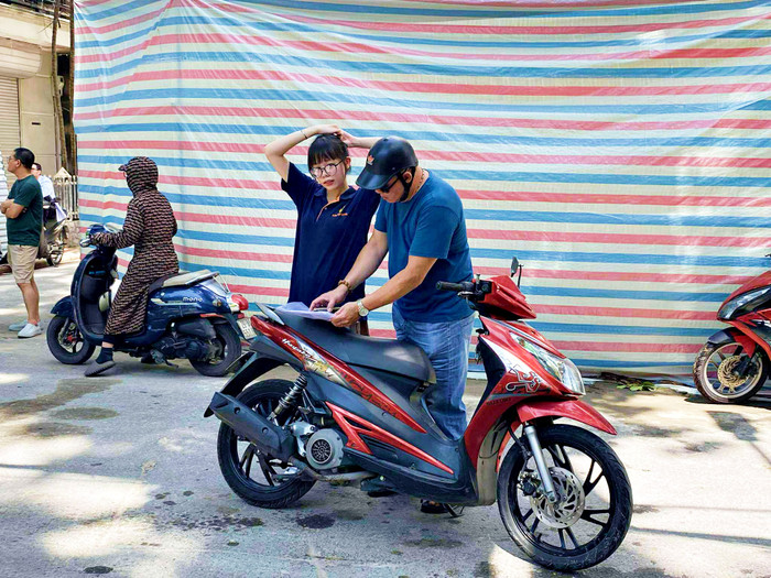 Phụ huynh đưa con đến điểm trường để làm thủ tục dự thi.