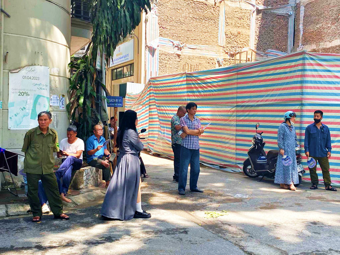 Phụ huynh nán lại cổng trường đợi con sau khi các sĩ tử vào làm thủ tục dự thi.