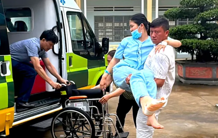 Người nhà bế em A. vào phòng thi. Ảnh: Báo Tiền Phong