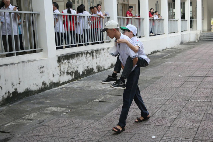 Hình ảnh nam sinh cõng bạn vào phòng thi khiến nhiều người xúc động. Ảnh: VietNamNet