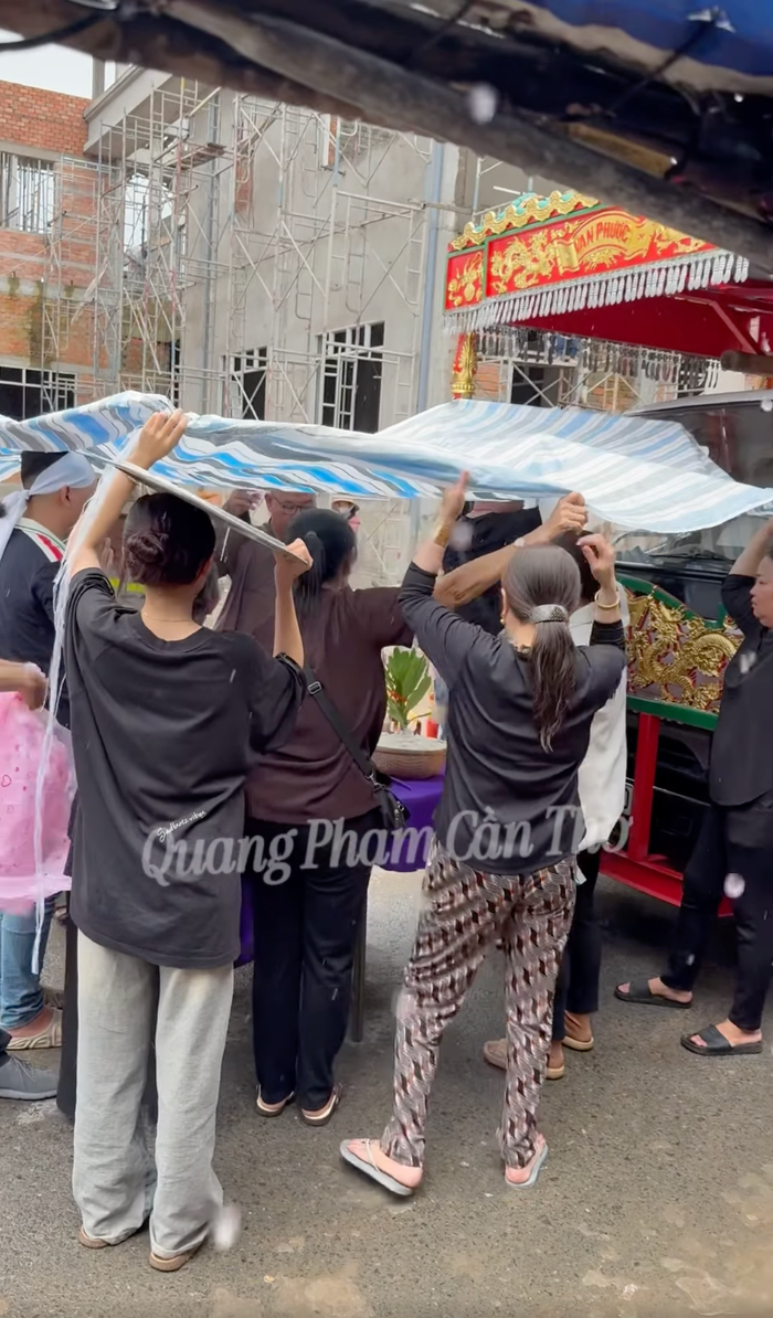 Trời đổ mưa lớn khi gia quyến tất bật làm các thủ tục, nghi lễ trong lễ động quan của người mẫu Nam Phong. Ảnh: Facebook Quang Phạm Cần Thơ