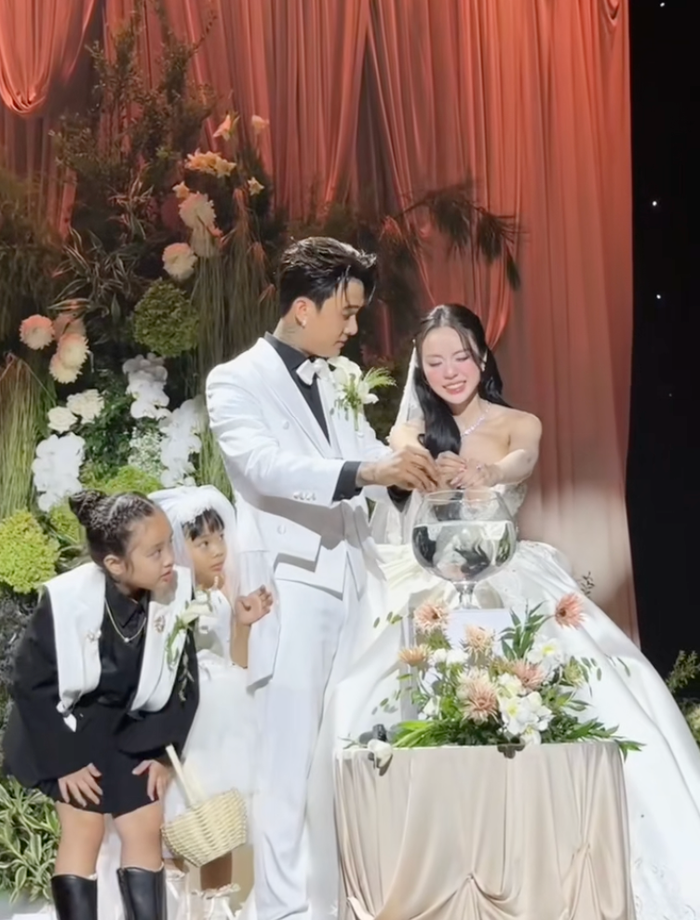 Đạt G và Cindy Lư nhỏ máu xuống cốc nước lớn trước sự chứng kiến của hai con. Ảnh: aimeebridal153