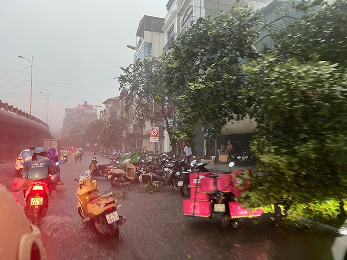 Mưa lớn kèm dông mạnh ở Hà Nội vào chiều 19/7 khiến nhiều người dân khó di chuyển trên đường. (Ảnh: Báo Quân Đội Nhân Dân)